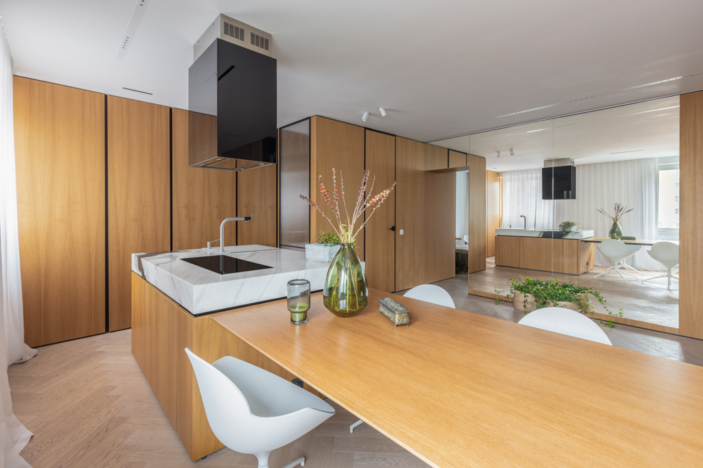 Contemporary kitchen with a marble countertop island and wood accents in a Berlin apartment.